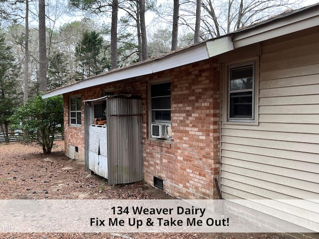 exterior space with crawl space, brick siding, cooling unit, and fence