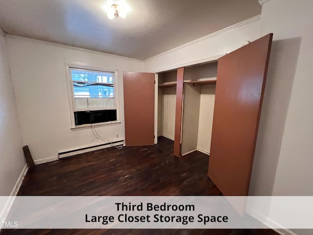 unfurnished bedroom with a baseboard heating unit, a closet, and dark wood finished floors