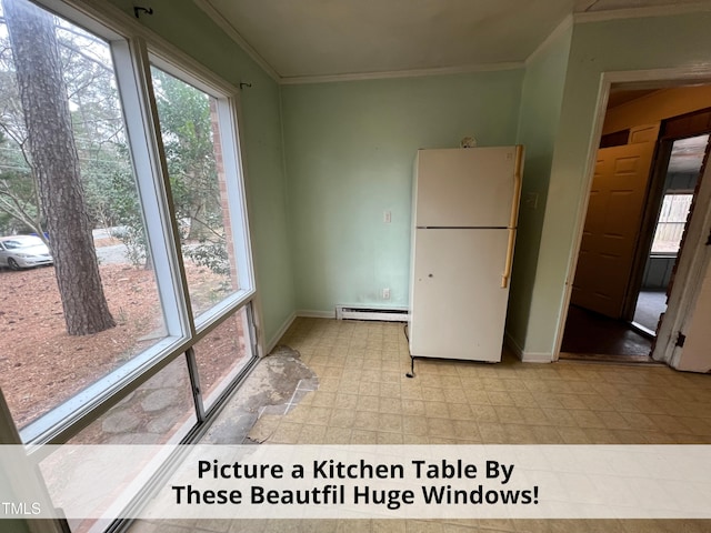 interior space featuring a baseboard heating unit, a wealth of natural light, freestanding refrigerator, and ornamental molding