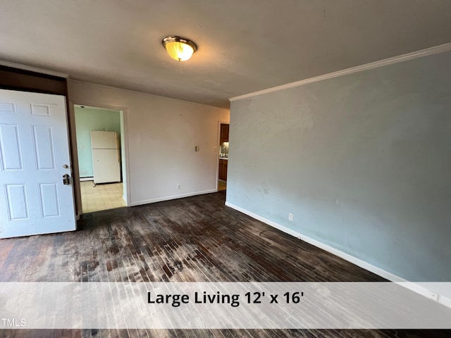 empty room featuring dark wood finished floors, crown molding, and baseboards