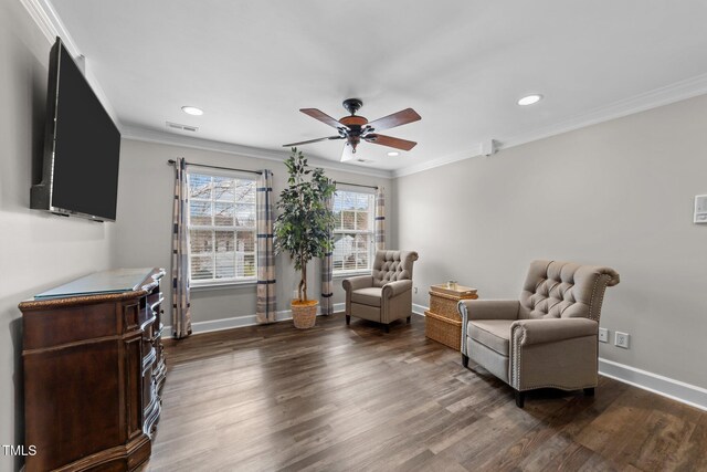 sitting room featuring baseboards, wood finished floors, visible vents, and ornamental molding