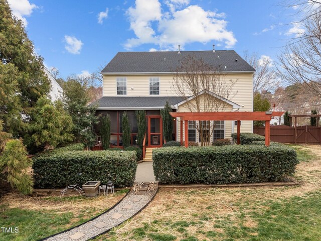 back of house featuring a shingled roof, a pergola, fence, and a sunroom