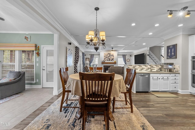 dining room with crown molding, wood finished floors, and baseboards