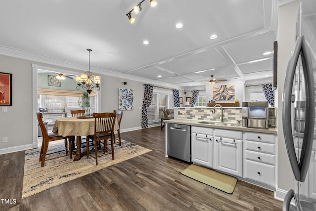 kitchen featuring decorative backsplash, ceiling fan with notable chandelier, appliances with stainless steel finishes, coffered ceiling, and a sink