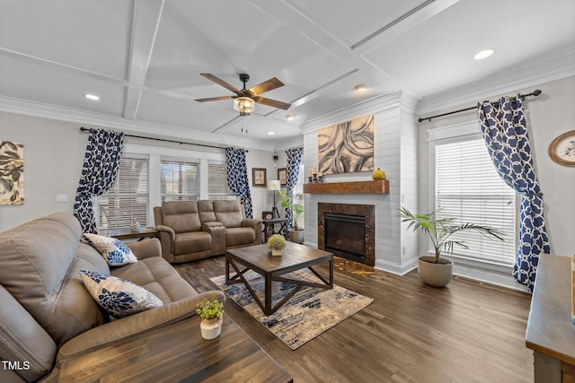 living area with crown molding, a fireplace, wood finished floors, coffered ceiling, and a ceiling fan