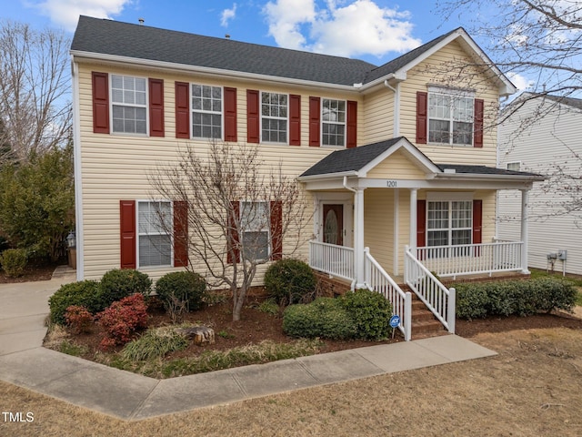 view of front of house featuring covered porch and a shingled roof