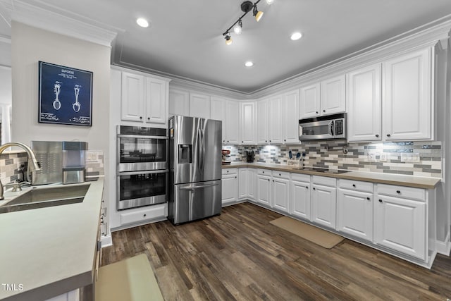 kitchen featuring tasteful backsplash, dark wood finished floors, appliances with stainless steel finishes, white cabinets, and a sink