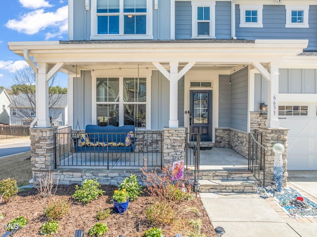 view of exterior entry featuring a garage, stone siding, a porch, and board and batten siding