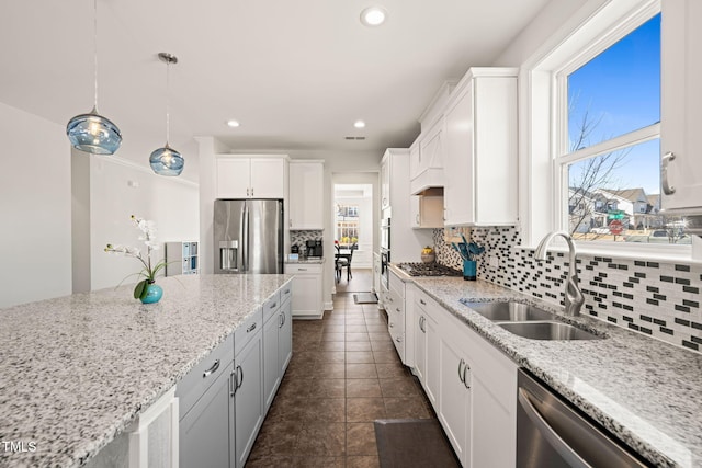 kitchen featuring stainless steel appliances, white cabinets, a sink, and decorative backsplash