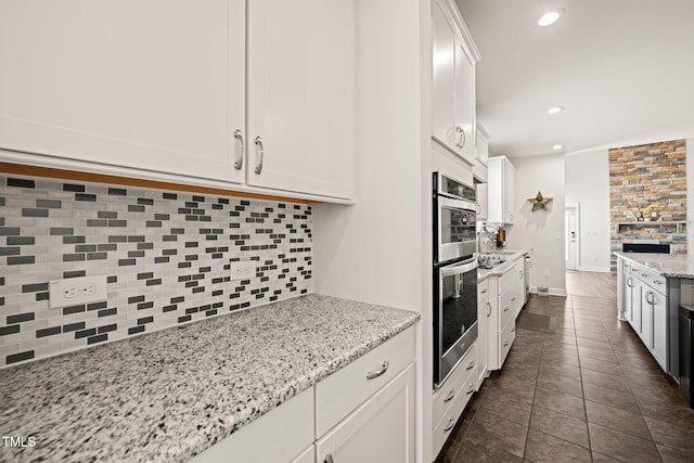 kitchen featuring tasteful backsplash, stainless steel double oven, white cabinetry, and recessed lighting