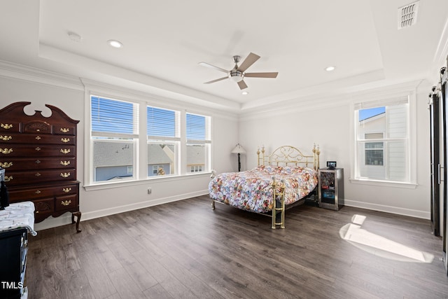 bedroom featuring baseboards, visible vents, a raised ceiling, and wood finished floors