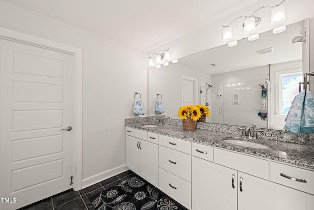 bathroom featuring double vanity, a stall shower, tile patterned flooring, and a sink