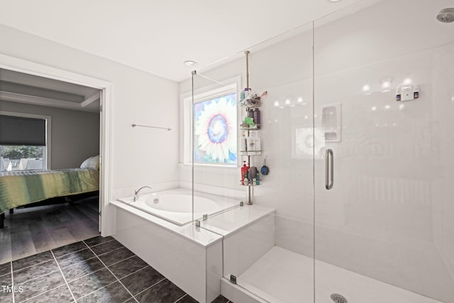 ensuite bathroom with ensuite bathroom, a shower stall, a bath, and tile patterned floors