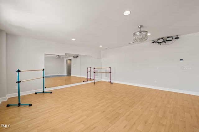 exercise area featuring light wood-style flooring, baseboards, and recessed lighting