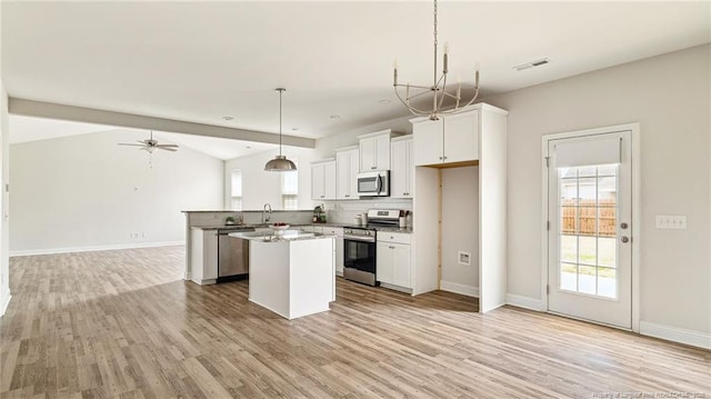 kitchen with visible vents, appliances with stainless steel finishes, open floor plan, a center island, and light wood-type flooring