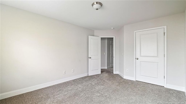 unfurnished bedroom featuring carpet floors and baseboards