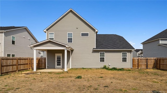 back of house featuring a yard, a fenced backyard, and a patio