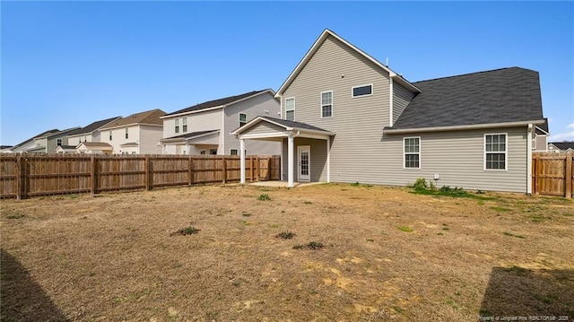 rear view of property with a fenced backyard and a residential view