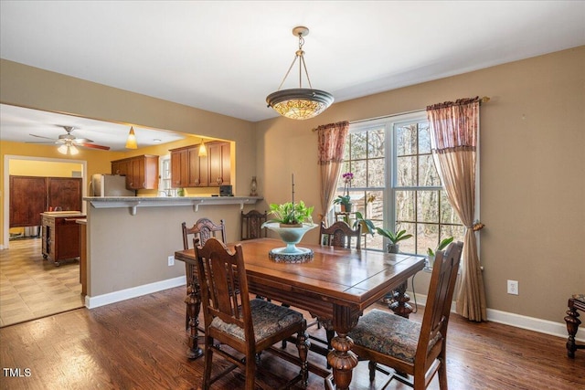 dining room featuring ceiling fan, baseboards, and wood finished floors