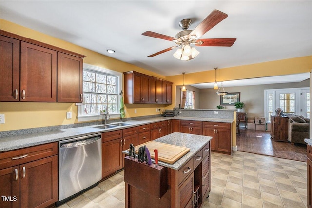 kitchen featuring a peninsula, a sink, a healthy amount of sunlight, open floor plan, and dishwasher