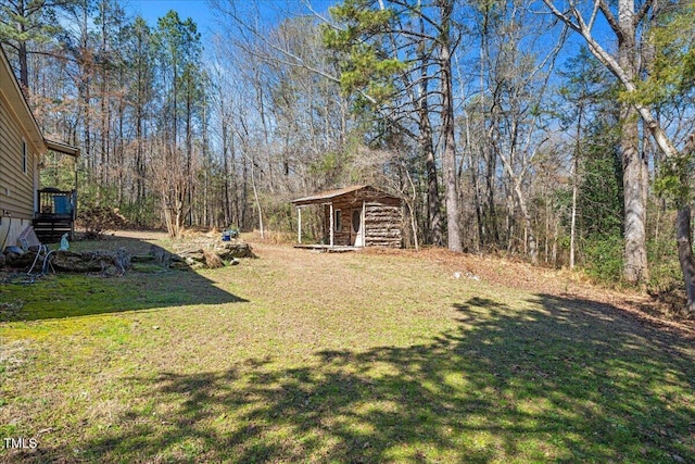 view of yard featuring an outdoor structure and a forest view