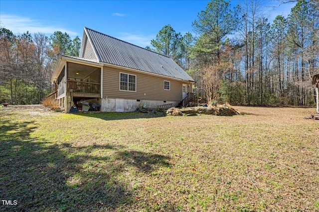 view of property exterior with metal roof, a yard, and crawl space