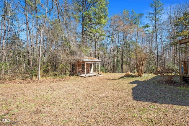 view of yard with a forest view and an outdoor structure