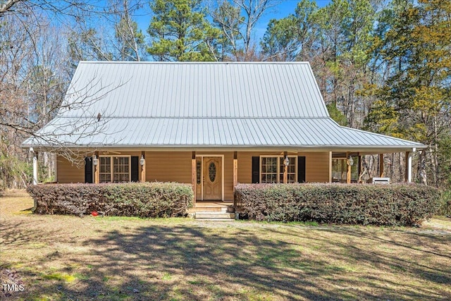 farmhouse-style home with a porch, a front yard, and metal roof