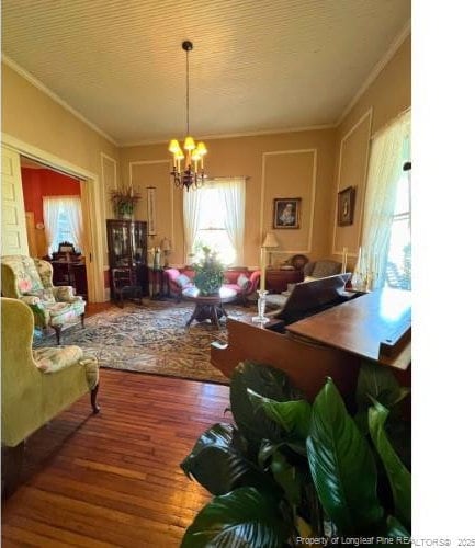 dining room featuring ornamental molding, a notable chandelier, and wood finished floors