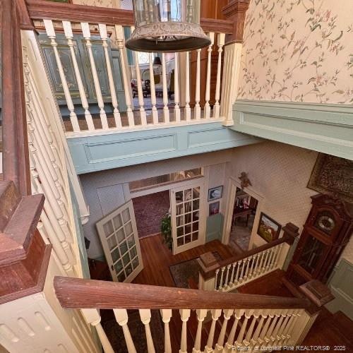 stairs featuring a wainscoted wall, a decorative wall, and wallpapered walls