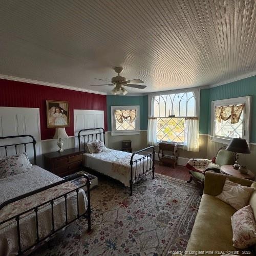 bedroom featuring ornamental molding, ceiling fan, and wood finished floors