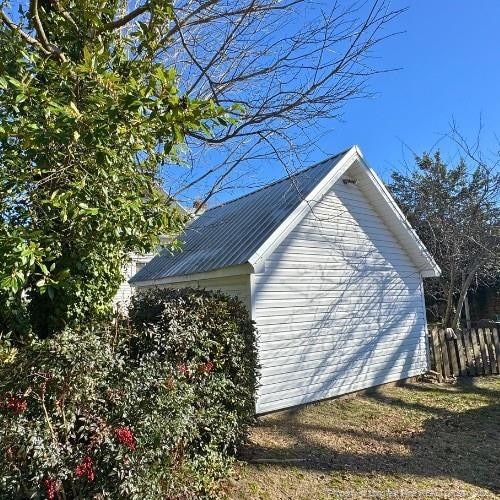 view of home's exterior featuring fence and metal roof