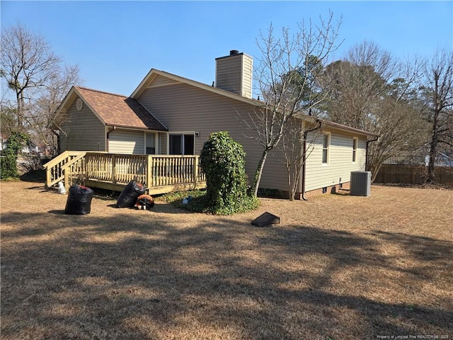 back of house featuring a shingled roof, central AC, a chimney, and a wooden deck