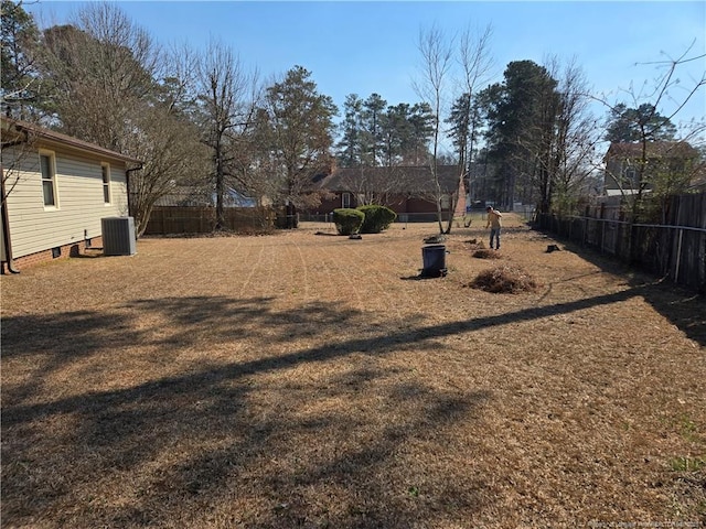 view of yard featuring fence and central AC