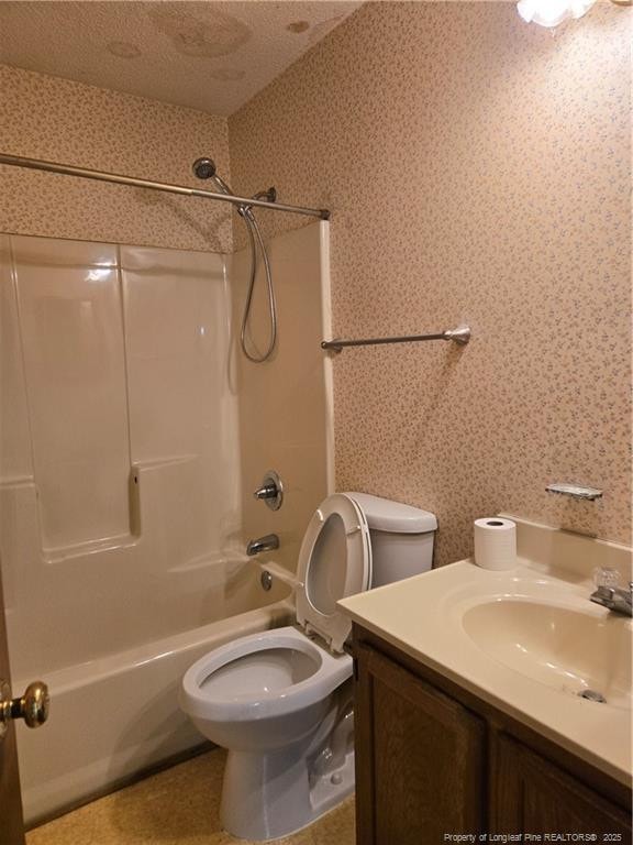 bathroom featuring a textured ceiling, toilet, vanity, shower / washtub combination, and wallpapered walls