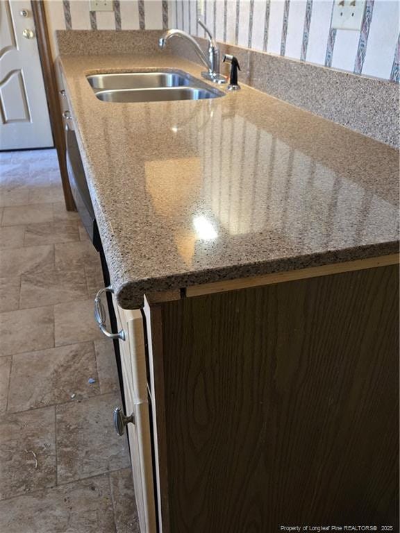 interior details featuring a sink and light stone countertops