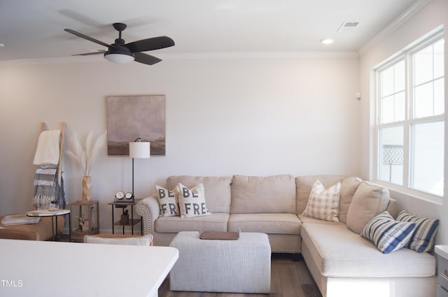 living room featuring a healthy amount of sunlight, visible vents, and ornamental molding