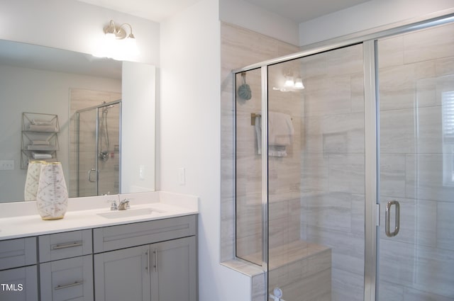 bathroom with a shower stall and vanity