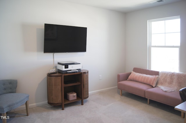 living area featuring baseboards and light carpet