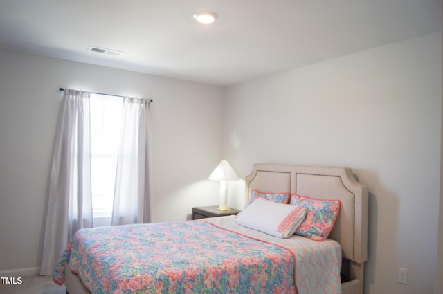 carpeted bedroom featuring visible vents