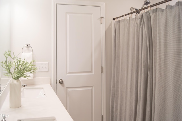 bathroom featuring curtained shower and a sink