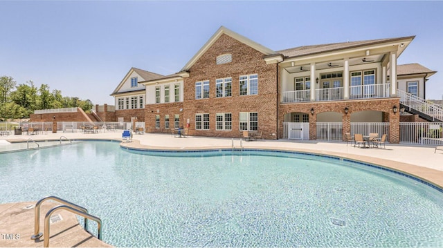 community pool with ceiling fan, a patio, and fence