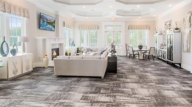 living area featuring recessed lighting, plenty of natural light, a high ceiling, and a glass covered fireplace