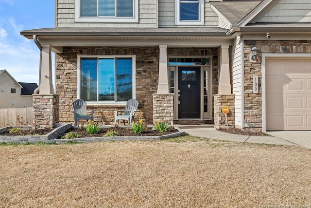 doorway to property featuring covered porch, stone siding, and a shingled roof