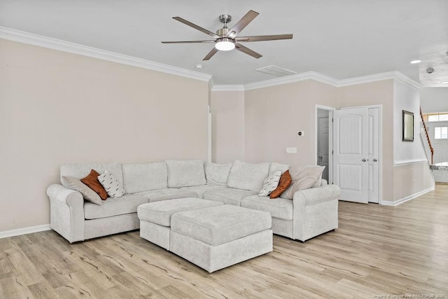 living area with baseboards, light wood finished floors, and crown molding