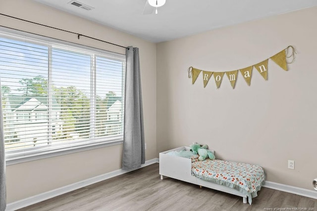 bedroom featuring baseboards, visible vents, and wood finished floors