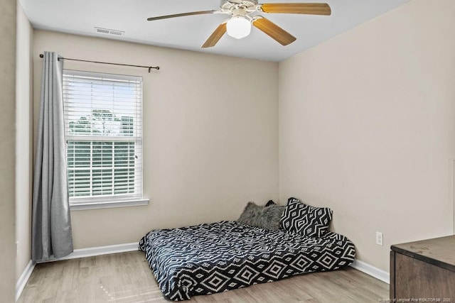 bedroom featuring visible vents, wood finished floors, a ceiling fan, and baseboards