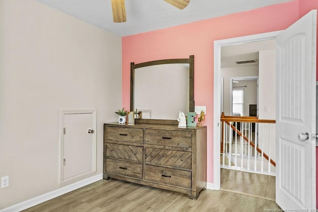 bedroom with a ceiling fan, light wood-type flooring, visible vents, and baseboards