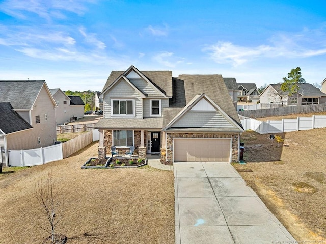 craftsman-style home featuring driveway, a garage, stone siding, a residential view, and fence