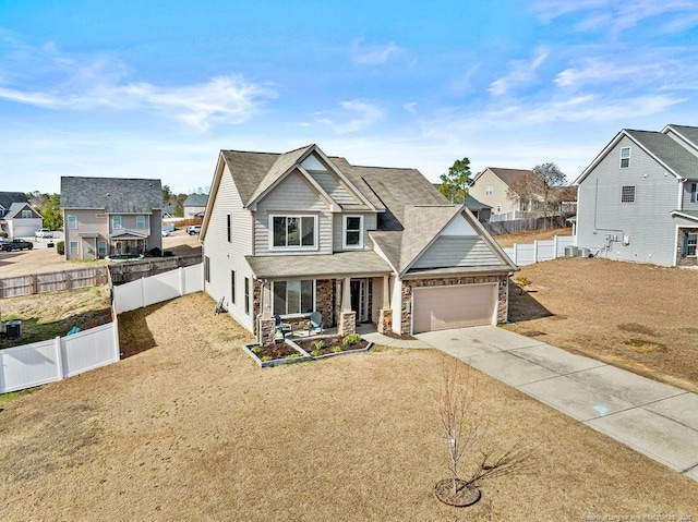 view of front facade featuring a garage, stone siding, fence, and concrete driveway